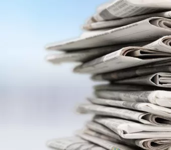 Stack of newspaper against a blurry background